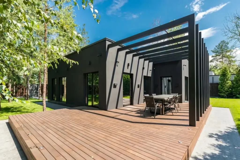 Stylish outdoor space Stylish outdoor space with wooden deck and dining set, surrounded by lush greenery.
